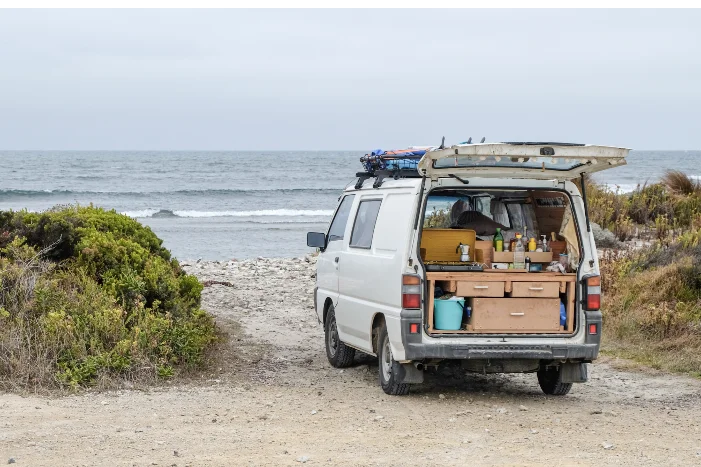 Ein Campingbus steht am Strand
